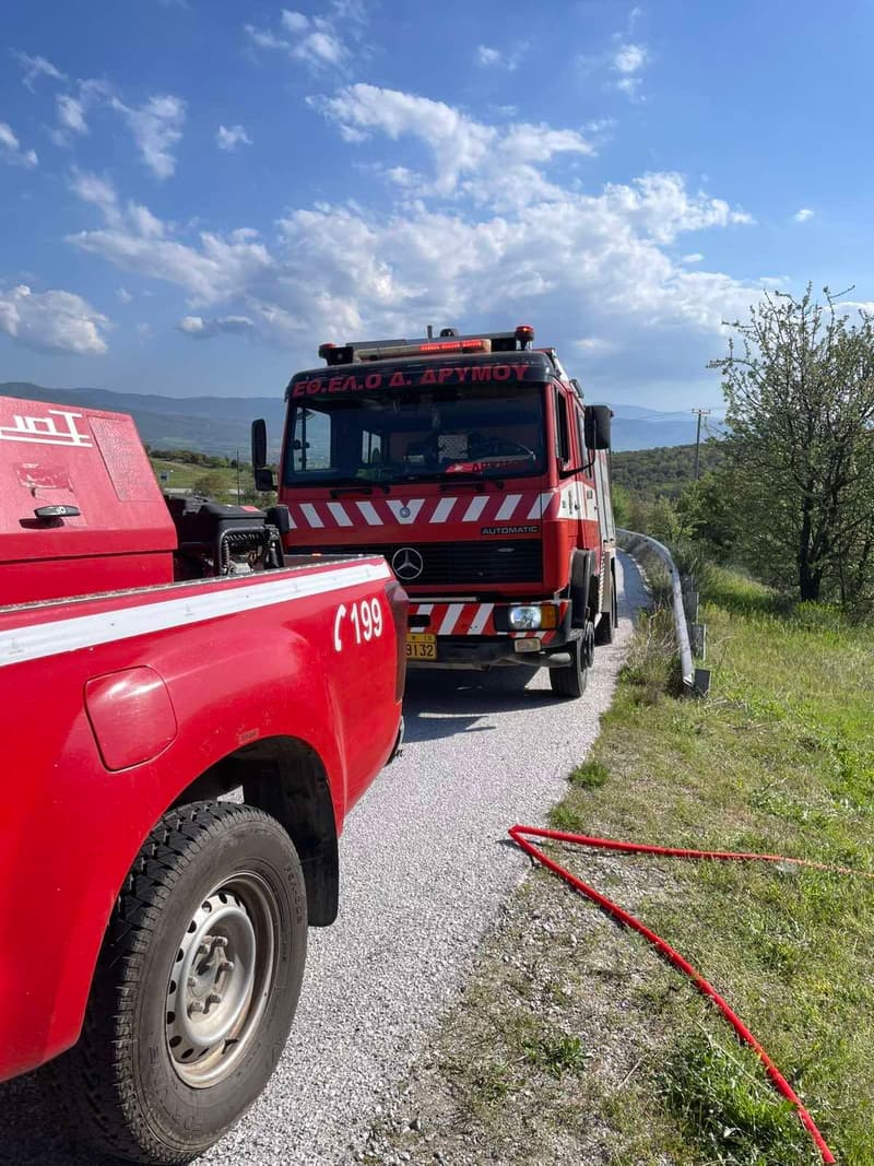 Όχημα της ομάδας και πυροσβεστικό σε αγροτικό δρόμο με απλωμένες μάνικες